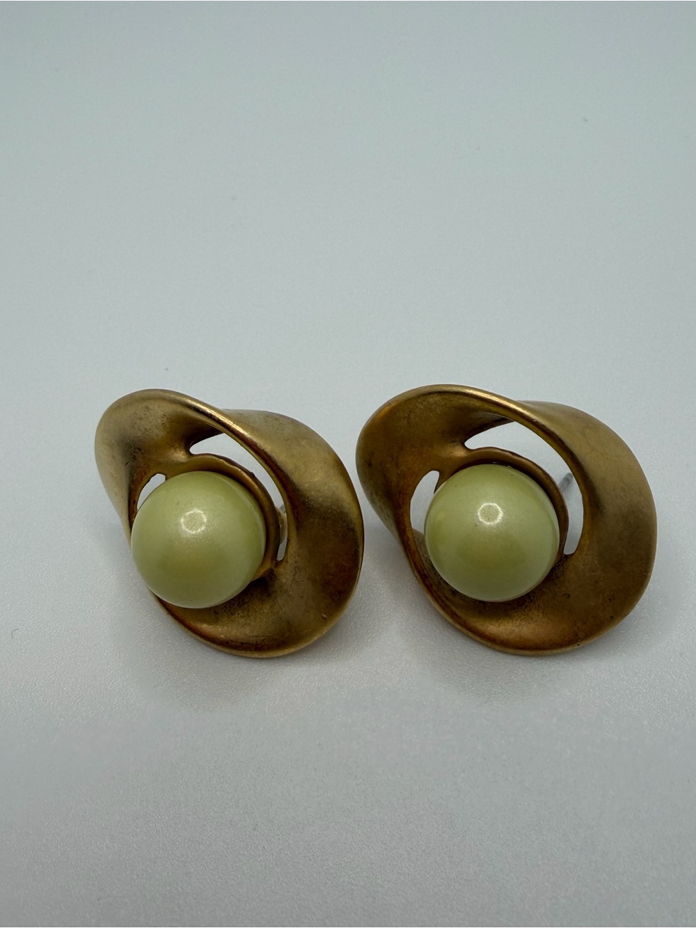 Vintage Napier matte gold swirl earrings with pistachio green faux pearls.